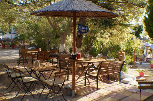 an outdoor table and chairs with an umbrella at Anatoli Hotel in Agia Marina Aegina