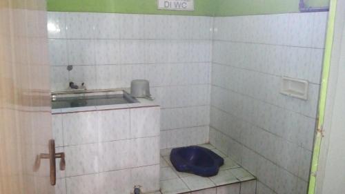 a bathroom with a toilet with a blue seat at Sedulur Homestay in Bromo