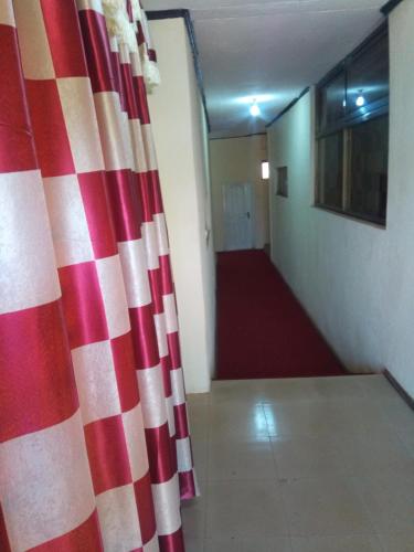 a hallway with a red and white curtain in a room at Nass Lodge in Sunyani