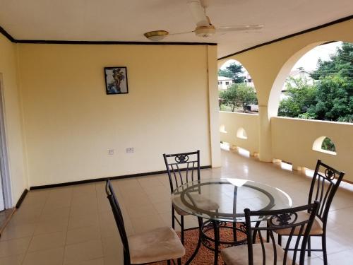 d'un balcon avec une table et des chaises en verre. dans l'établissement Nass Lodge, à Sunyani