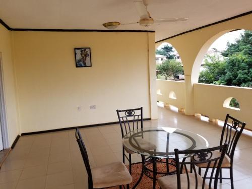 a balcony with a glass table and chairs at Nass Lodge in Sunyani