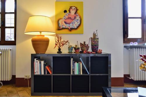 a black book shelf with a lamp on top of it at Alberto Charming Home in Montepulciano