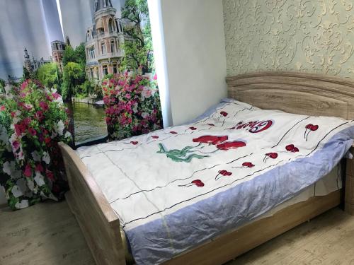 アドレルにあるApartment on ulitsa Lenina 219к2の花の飾られた部屋のベッド1台