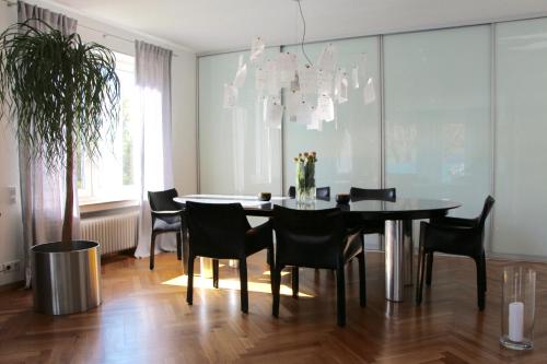 a dining room with a black table and chairs at MOZART42 in Fellbach