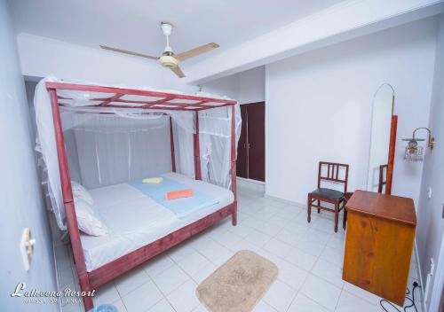 a bedroom with a canopy bed and a chair at Latheena Resort in Weligama