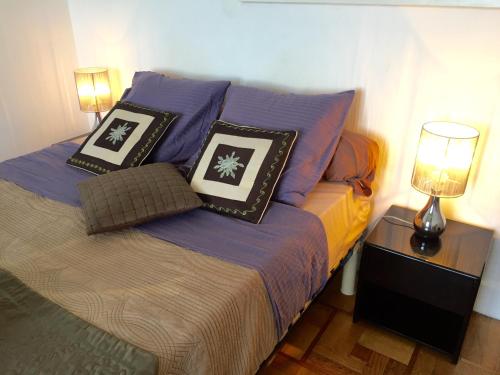 a bed in a room with pillows on it at Beachfront apartment Promenade Des Anglais in Nice