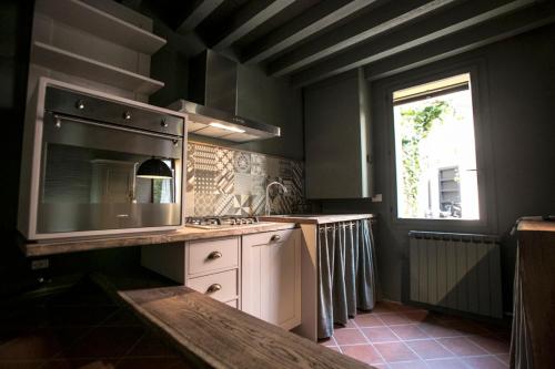 kuchnia z kuchenką, umywalką i oknem w obiekcie Cà Tugnin Dill Cich w mieście Ferrara