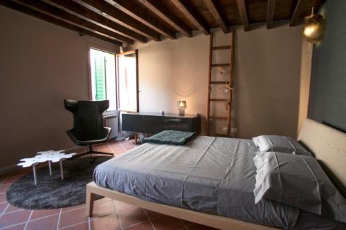 sypialnia z łóżkiem, biurkiem i krzesłem w obiekcie Cà Tugnin Dill Cich w mieście Ferrara