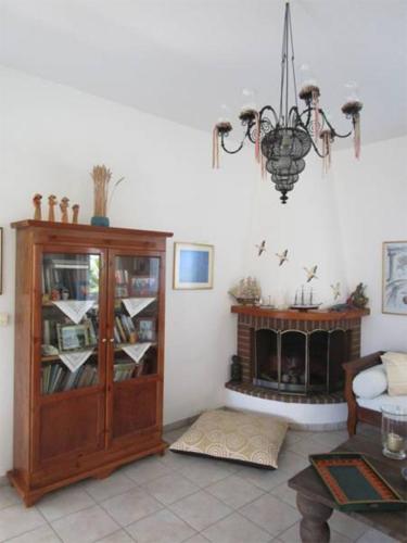 a living room with a book shelf and a chandelier at Villa Porto Matzavino in Vonitsa