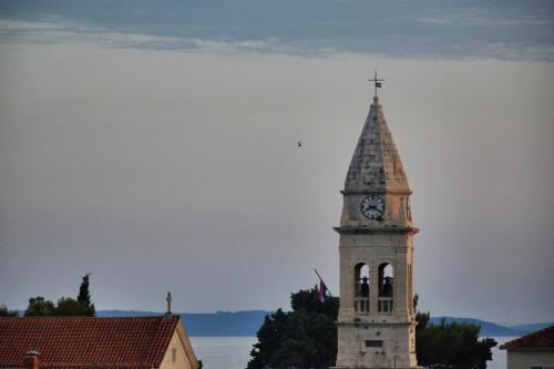 a clock tower with a cross on top of it at Rooms&Apartments Zelux in Split
