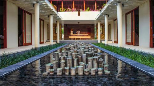 a room with a bunch of cups in the middle of a building at Qunci Villas Resort in Senggigi 