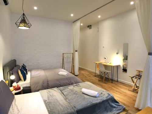 a bedroom with two beds and a desk in it at iBook Gurney Suites in George Town