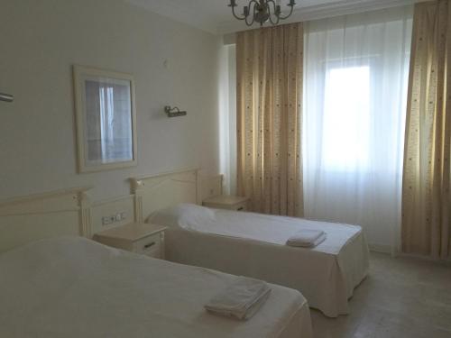 カーギジャックにあるApartments in Goldcity Tourist Complexの白い部屋で、ベッド2台、窓が備わります。
