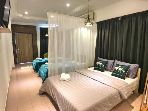 a bedroom with a large white bed with curtains at iBook Gurney Suites in George Town