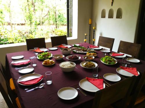 een tafel met borden en kommen met eten erop bij IKSHAA Luxury Villa with Private Pool in Majorda