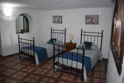a bedroom with two beds and a mirror at Holiday Home El Brezal in El Palmital
