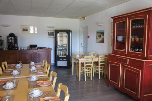 ein Esszimmer mit Tischen und Stühlen und eine Küche in der Unterkunft Hotel Terriciaë aux portes de Maussane les Alpilles in Maussane-les-Alpilles