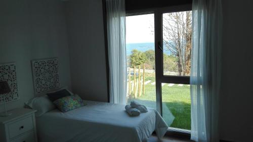 a bedroom with a bed and a large window at Casa Nueva Playa Areabrava Hio in Hio