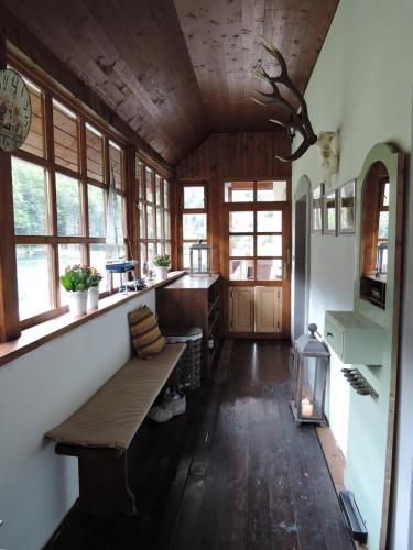 a kitchen with a bench in a room with windows at Chata Motyčky in Donovaly
