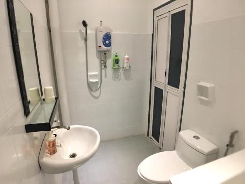 a bathroom with a shower and a toilet and a sink at iBook Gurney Suites in George Town