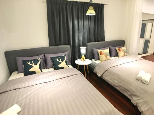 a bedroom with two beds and a table between them at iBook Gurney Suites in George Town