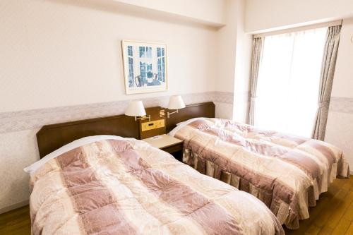 Habitación con 2 camas y ventana en Hotel G-Style en Sayo