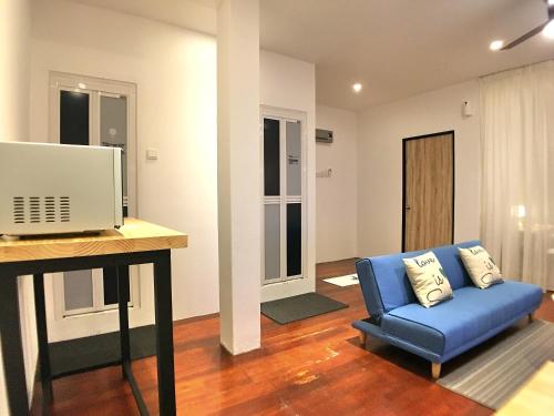 a living room with a blue couch and a desk at iBook Gurney Suites in George Town