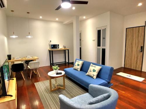 a living room with a blue couch and a table at iBook Gurney Suites in George Town