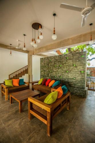 a living room with couches and colorful pillows at Anantamaa Hotel in Trincomalee