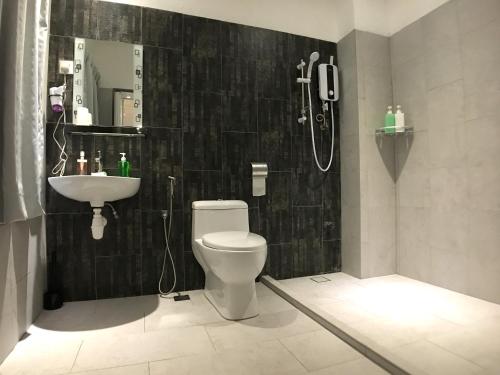 a bathroom with a white toilet and a sink at iBook Gurney Suites in George Town