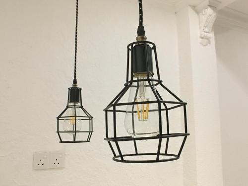three pendant lights hanging from a wall at iBook Gurney Suites in George Town