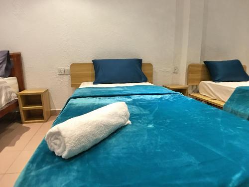 a hospital room with two beds with blue sheets at iBook Gurney Suites in George Town