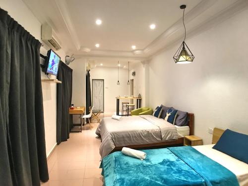 a hotel room with two beds and a television at iBook Gurney Suites in George Town