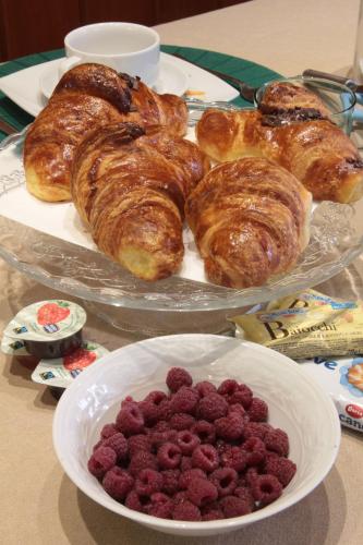 a plate of pastries and a bowl of raspberries on a table at B&B Villa Mirella in Bordighera