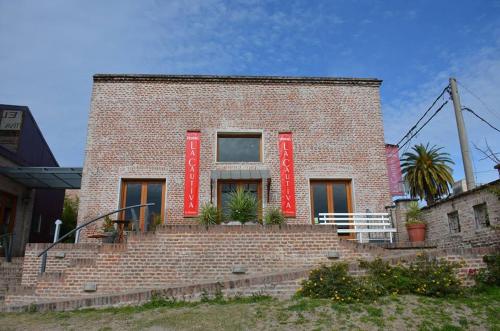 a brick building with red shutters on it at Hotel La Cautiva de Ramirez in La Paz