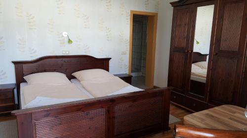a bedroom with a wooden bed and a cabinet at Pension Weiß in Zinnowitz