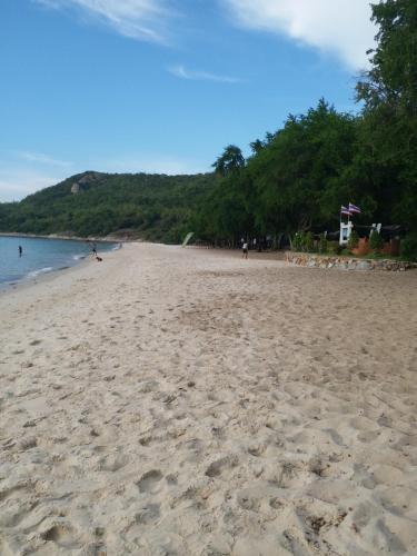 una playa de arena con gente caminando en el agua en Baan Chockchai 3, en Bang Sare