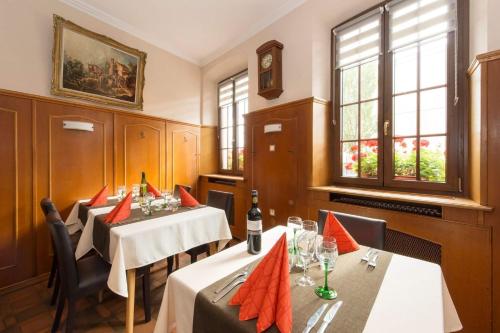 a dining room with two tables with red napkins at Hotel Restaurant de l'Europe in Wissembourg