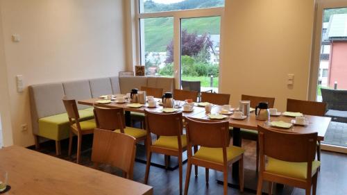 a dining room with a table and chairs and a window at Gästehaus Vinaria in Kinheim