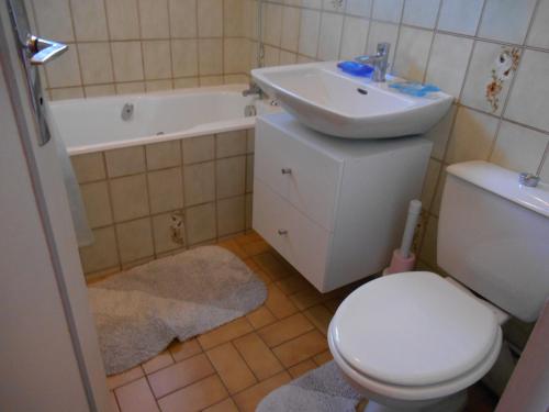 une salle de bain avec des toilettes blanches et un lavabo dans l'établissement Gite de la Tréherais, à Saint-Malo