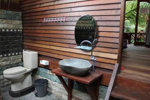 a bathroom with a sink and a toilet on a deck at Bronze Bungalows in Gili Meno