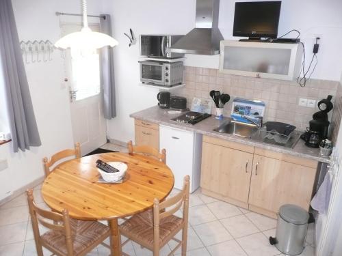 une cuisine avec une table en bois et une table et des chaises dans l'établissement Escale Baie de Somme, à Saint-Valery-sur-Somme