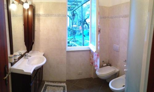 łazienka z umywalką, toaletą i oknem w obiekcie A cà du Baciccia w mieście Oneto