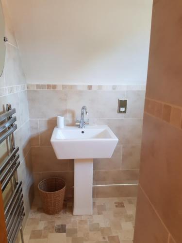 a bathroom with a white sink in a room at Weir Cottage in Fordingbridge