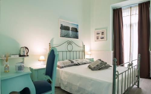 a bedroom with a bed and a blue chair at Dimora Partenopea in Naples