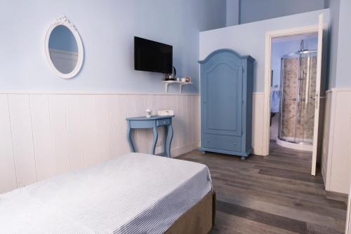 1 dormitorio con 1 cama y armario azul en Dimora Partenopea, en Nápoles