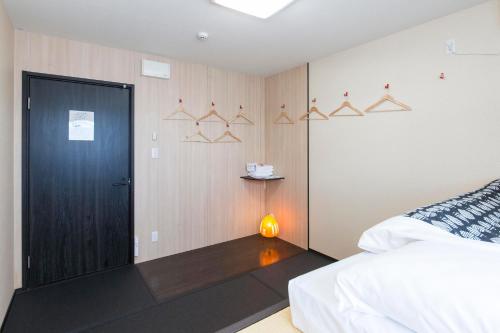 a bedroom with a bed and a black door at Fujitaya BnB in Kyoto