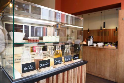 a glass display case in a kitchen with bottles of alcohol at Hotel Marcel in Bruges