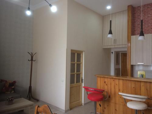 eine Küche mit roten Stühlen und einer Theke in einem Zimmer in der Unterkunft Modern Apartment Avlabari in Tbilisi City