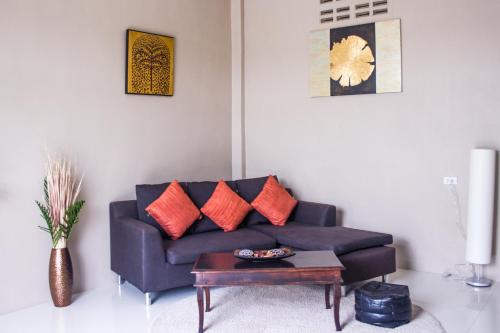 a living room with a blue couch with orange pillows at The Miracle Guesthouse & Diving in Koh Tao